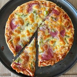 Eine Tiefkühlpizza liegt auf einem Teller.